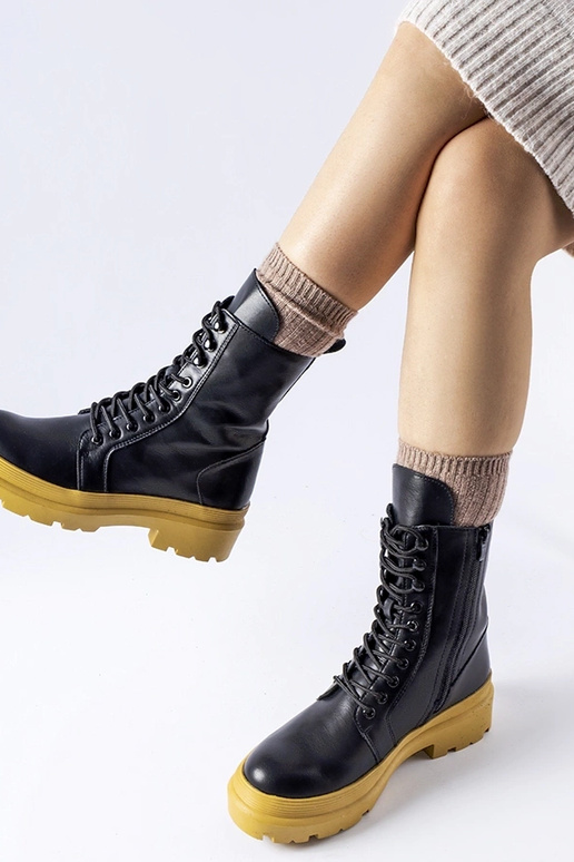 Schwarze Winterstiefel auf gelber...