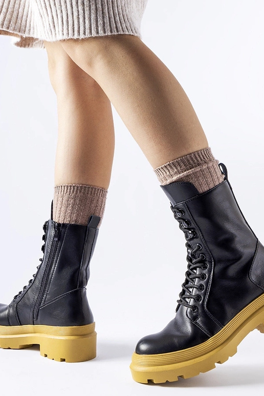 Schwarze Winterstiefel auf gelber...