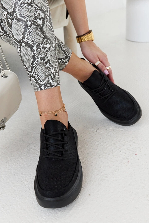 Schwarze Damen-Sneaker auf der... Schwarze Damen-Sneaker auf der...