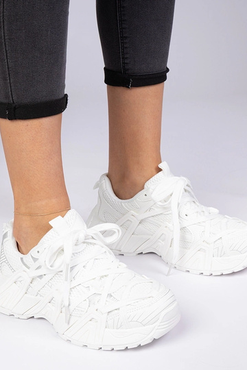 Weiße Sneakers auf massiver...