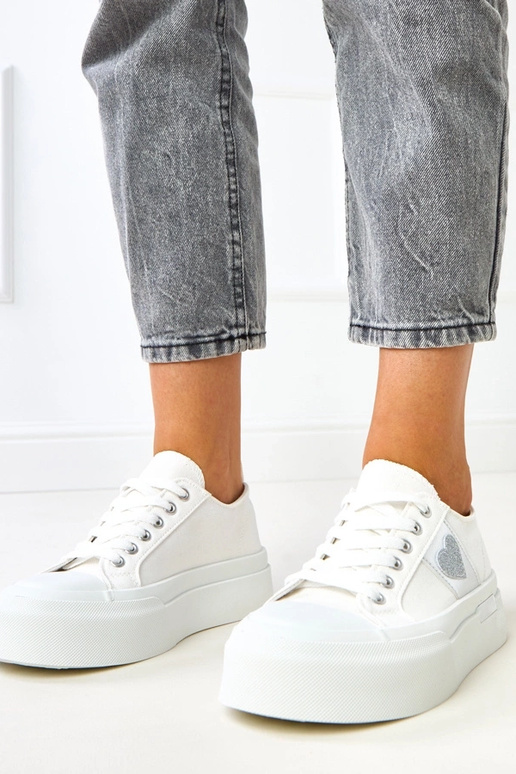 Weiße Sportpantoletten auf Plattform...