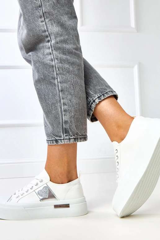 Weiße Sportpantoletten auf Plattform...