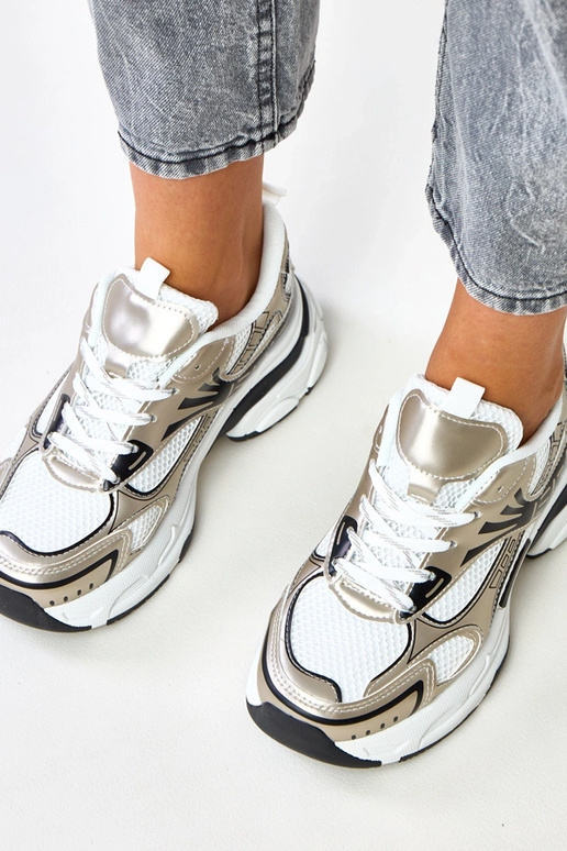 Goldene Sportschuhe auf massivem...