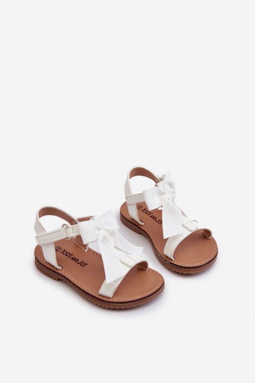 Lackierte Kindersandalen mit Bändern und Klebeverschlüssen in der Farbe Weiß Joratia Lackierte Kindersandalen mit Bändern und Klebeverschlüssen in der Farbe Weiß Joratia